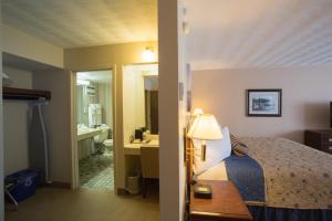 a hotel room with a bed and a bathroom at The Fredericton Inn in Fredericton