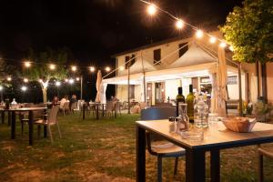a group of tables and chairs at night with lights at Agriturismo La Querciola in Riolo Terme