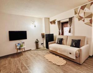 un soggiorno con divano e TV a schermo piatto di Casa Kristel CIR COMUNALE N 14 ad Aosta