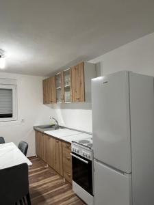 une cuisine avec un réfrigérateur blanc et des placards en bois dans l'établissement Rakocevic house, à Kolašin