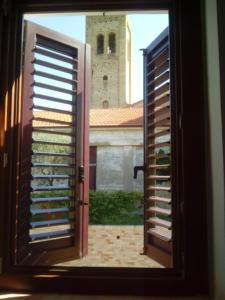 una finestra aperta con vista su una torre dell'orologio di La Casetta del Muratore a Recanati