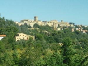 una città sulla cima di una collina con alberi di La Casetta del Muratore a Recanati