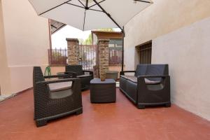 a patio with wicker chairs and an umbrella at Domus Fabia - Rooms & Apartments in San Gemini +9 photos