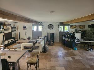 un salon rempli de meubles et une horloge au mur dans l'établissement Gite Les Quatre Alouettes, à Mazières-de-Touraine