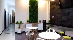 a room with tables and chairs and a green wall at Tropical Point Hotel Syariah in Pipulu +69 photos