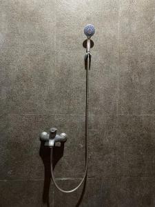 een douche met een slang aan een muur bij Villa Azzyra in Pakem
