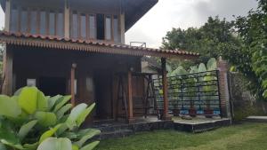 een klein huis met een hek naast een tuin bij Villa Azzyra in Pakem