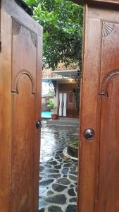 een open deur naar een binnenplaats met een huis bij Villa Azzyra in Pakem +10 foto's