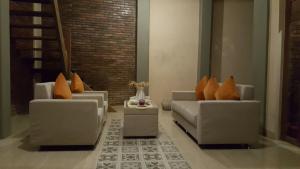 soggiorno con divani e cuscini arancioni di Villa Azzyra a Pakem Altre 10 foto