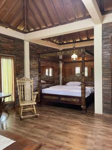 una camera da letto con un letto grande e una sedia di Villa Azzyra a Pakem