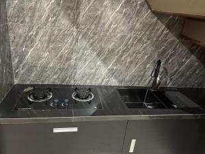 a black counter top with a sink in a kitchen at Villa Azzyra in Pakem