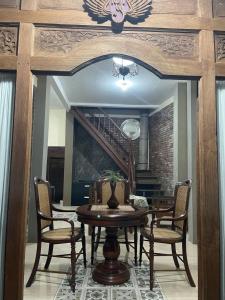 una sala da pranzo con tavolo, sedie e scala di Villa Azzyra a Pakem