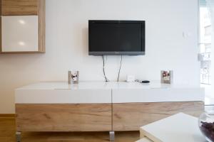 a tv sitting on top of a dresser in a living room at Prima Apartmani Beograd in Belgrade