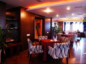 a restaurant with a red table and chairs in a room at Chengdu Huadu Times Hotel in Chengdu