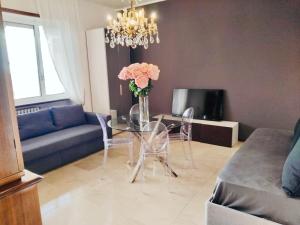 een woonkamer met een glazen tafel met een vaas met bloemen bij Charming Central Relais in Bergamo