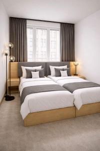 - 2 lits dans une chambre avec 2 fenêtres dans l'établissement Niko Hotel am Hannover Hbf, à Hanovre