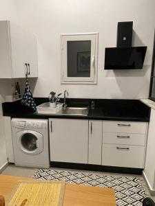 uma cozinha com pia e máquina de lavar em Blueyes em La Marsa