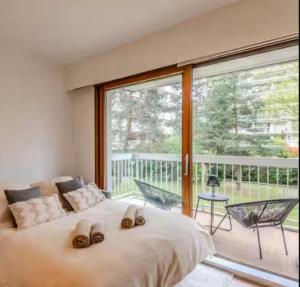 Un dormitorio con una cama y una ventana grande. en L'Appart 32 - Appartement confortable et au calme, en Annecy
