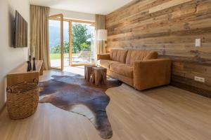 a living room with a couch and a wooden wall at Sun Lodge Schladming by Schladming-Appartements in Schladming