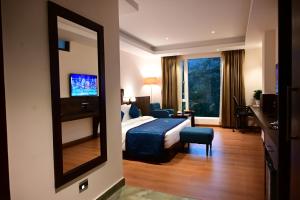 ein Hotelzimmer mit einem Bett und einem Spiegel in der Unterkunft Click collection Gangtok in Gangtok