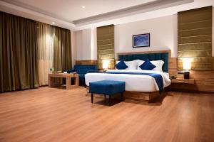 ein Schlafzimmer mit einem großen Bett und einem blauen Stuhl in der Unterkunft Click collection Gangtok in Gangtok