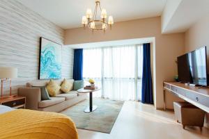 TV a/nebo společenská místnost v ubytování Qingdao Yiran Wanjia Hotel Apartment (May Fourth Square Wanxiang City Branch)