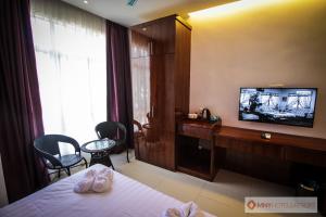 a hotel room with a bed and a television at MNY Hotel & Resort in Pangkor