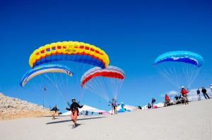 a group of people flying kites on a beach at Sundia By Liberty Oludeniz in Oludeniz