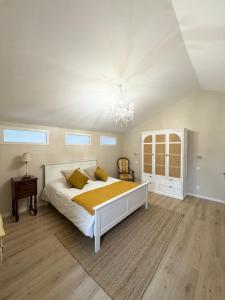 een slaapkamer met een groot wit bed en een kroonluchter bij La Bastide des Trembles in Marseille