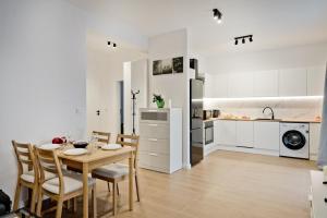 eine Küche und ein Esszimmer mit Tisch und Stühlen in der Unterkunft Apartamenty IN Leśna in Hel