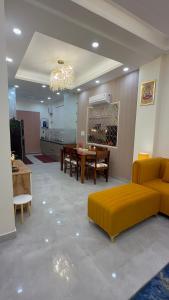 a living room with a yellow couch and a table at NIVAASe STAYS in New Delhi