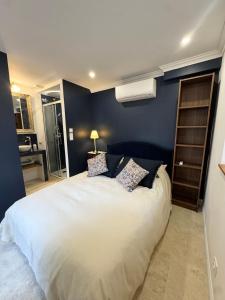 een slaapkamer met een groot bed met een blauwe muur bij La Bastide des Trembles in Marseille