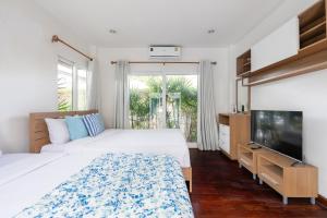 ein Schlafzimmer mit zwei Betten und einem Flachbildfernseher in der Unterkunft Sorrento Pool Villa Bang Lamung Pattaya in Ban Rong Po