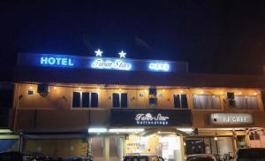 a hotel with a sign on the front of it at night at Twin Star Hotel in Kampong Keteyong
