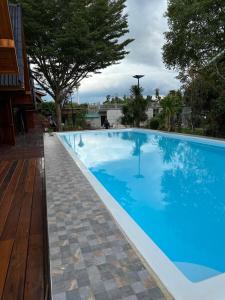 een groot blauw zwembad met een houten terras bij บ้านพิมพ์วนาเขาใหญ่ ห้องมินิ in Ban Tha Maprang