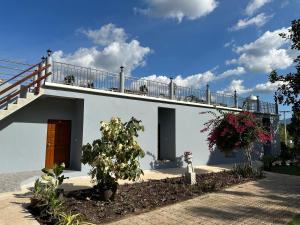 een wit huis met een balkon erbovenop bij บ้านพิมพ์วนาเขาใหญ่ ห้องมินิ in Ban Tha Maprang