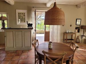 een eetkamer met een tafel en een kat die op het aanrecht zit bij Le Mas En Provence in Entrechaux