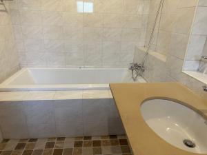 een badkamer met een bad en een wastafel bij บ้านพิมพ์วนาเขาใหญ่ ห้องมินิ in Ban Tha Maprang