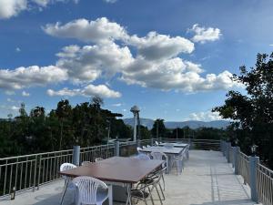 een rij tafels en stoelen op een balkon bij บ้านพิมพ์วนาเขาใหญ่ ห้องมินิ in Ban Tha Maprang