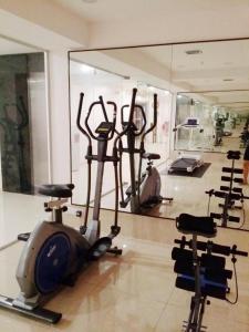einen Fitnessraum mit mehreren Heimtrainern und einem Spiegel in der Unterkunft KTC HOTEL in Bidur