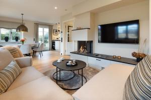 een woonkamer met een bank en een tafel met een open haard bij Dünenhafer in List