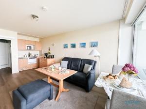 een woonkamer met een bank en een tafel bij Haus Nautic Wohnung 615 in Döse