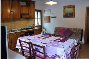 een keuken met een tafel met een paars tafelkleed bij Appartamento Il Bosco Incantato in Abetone