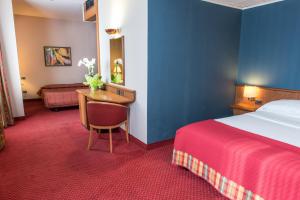 Una habitación de hotel con una cama y un escritorio en una habitación en Idea Hotel Piacenza, en Piacenza