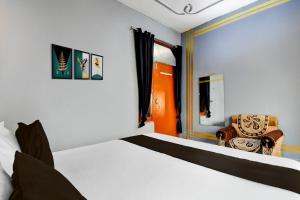 a bedroom with a bed and a chair at HOTEL O STAY INN Lucknow Airport VIP Terminal in Transport Nagar