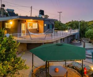 ein Haus mit einem grünen Regenschirm davor in der Unterkunft Karel house in Karés