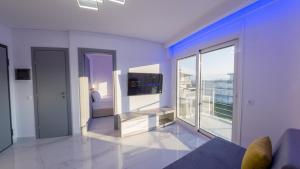 a living room with a tv and a large window at Delfini Girni Apartments in Paralia Katerinis