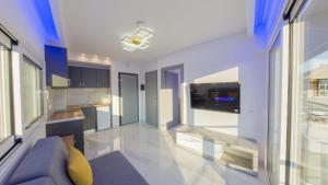 a living room with a couch and a kitchen at Delfini Girni Apartments in Paralia Katerinis +13 photos