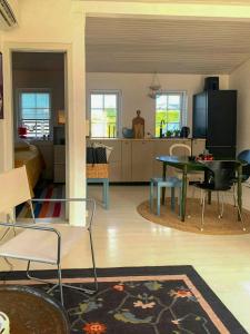a living room with a table and a kitchen at Ferienhaus In Strandnähe In Otterup in Kristiansminde +12 photos