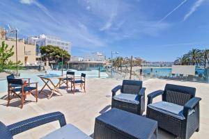 patio z krzesłami i stołem z widokiem na wodę w obiekcie Apartments Beach 4U - Can Pastilla w mieście Can Pastilla